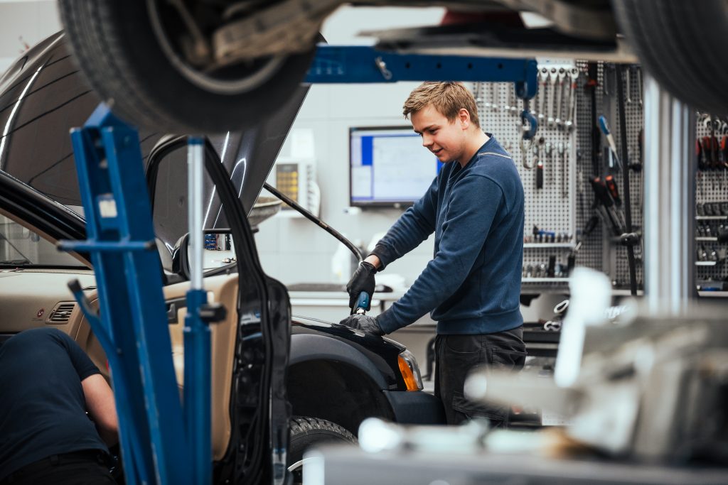 Mekaniker jobber med motorrommet til en bil på verksted