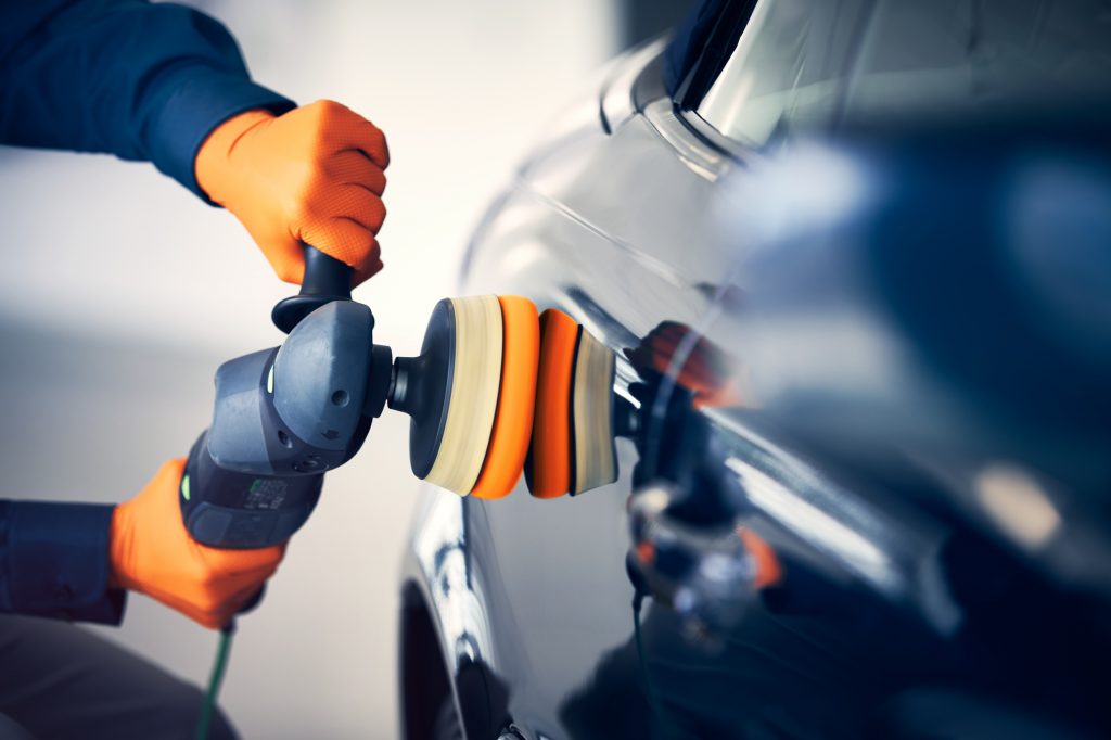 Svart bil poleres med poleringsmaskin