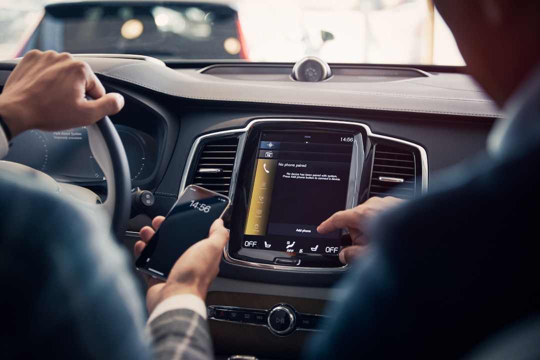 To personer sitter i forsete av en bil og er på digitalskjerm