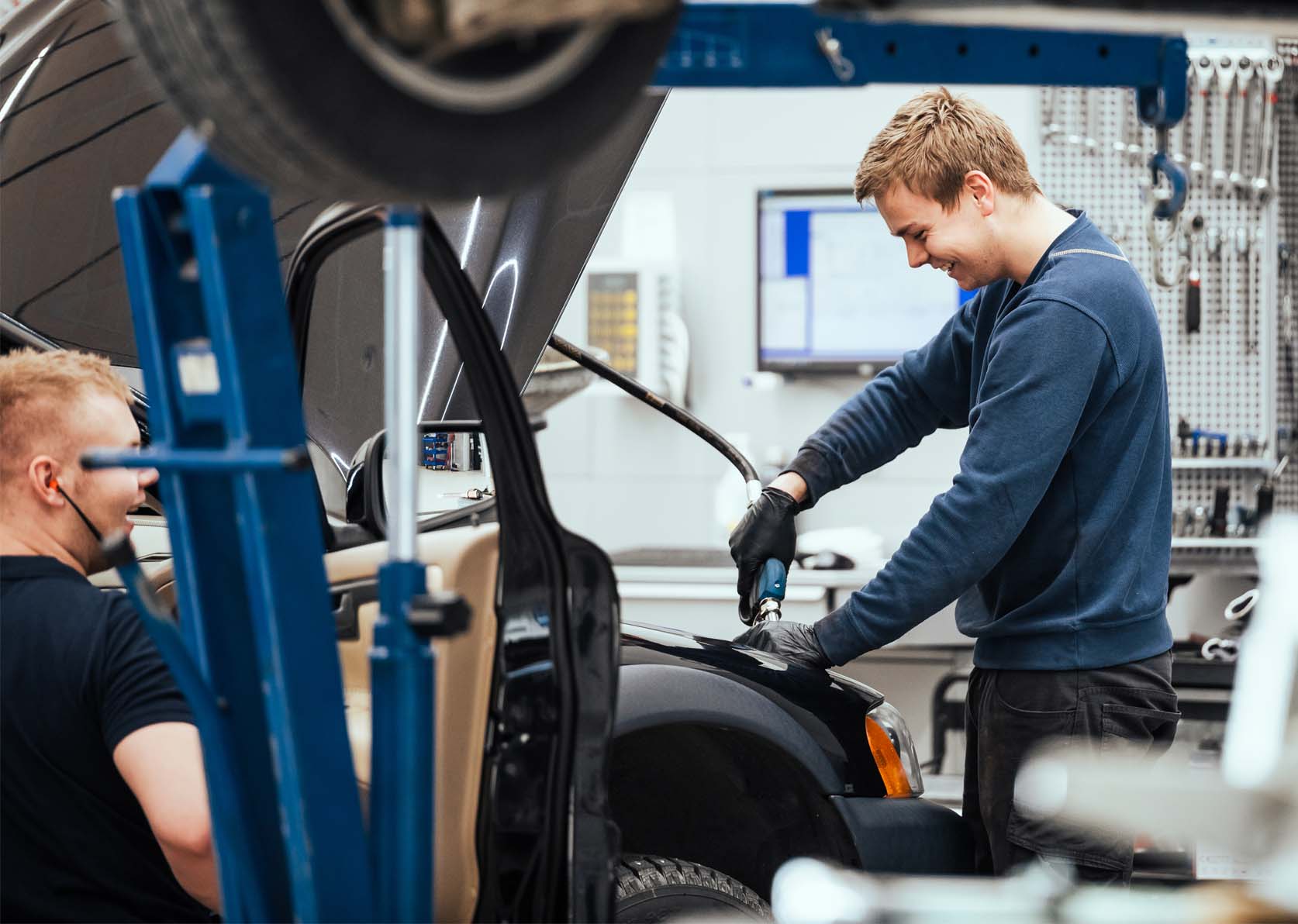 Mekaniker jobber i motorrommet på en bil