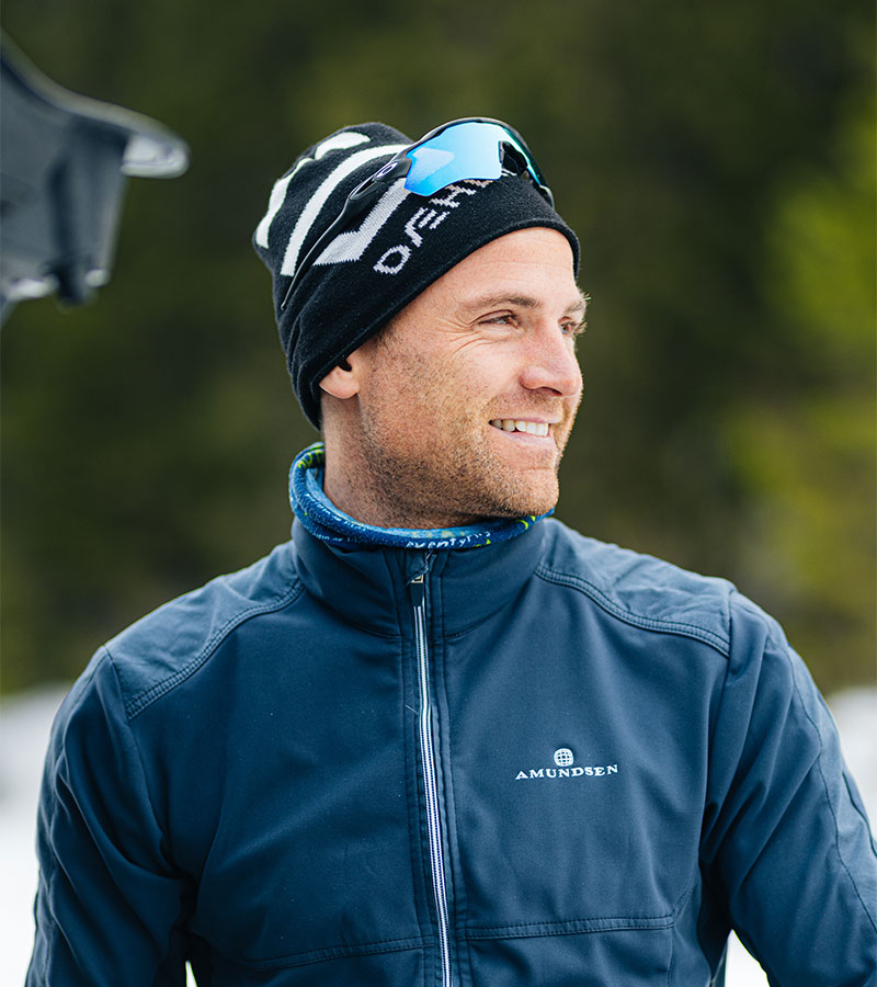 Niklas Dyrhaug i blå langrennsjsakke med lue og raske briller på hodet