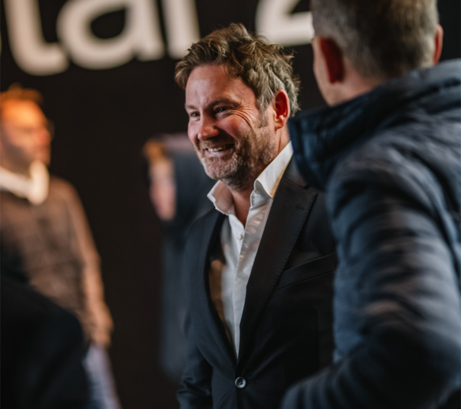 Smilende mann i dress og hvit skjorte