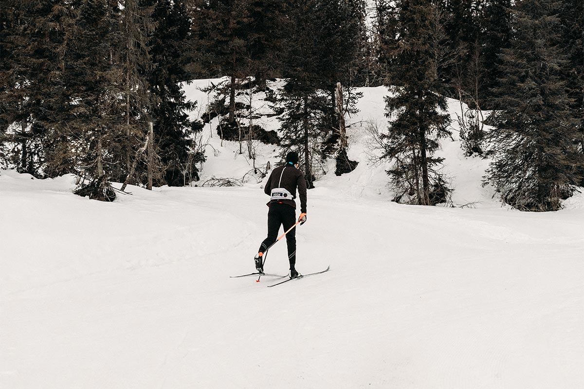 Mann (Emil Iversen) i mørk skibekledning går på langrennski