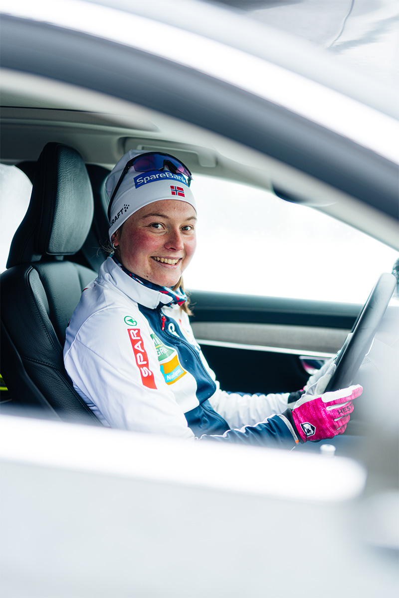 Jente sitter i førersete i en nil med langrennstøy på